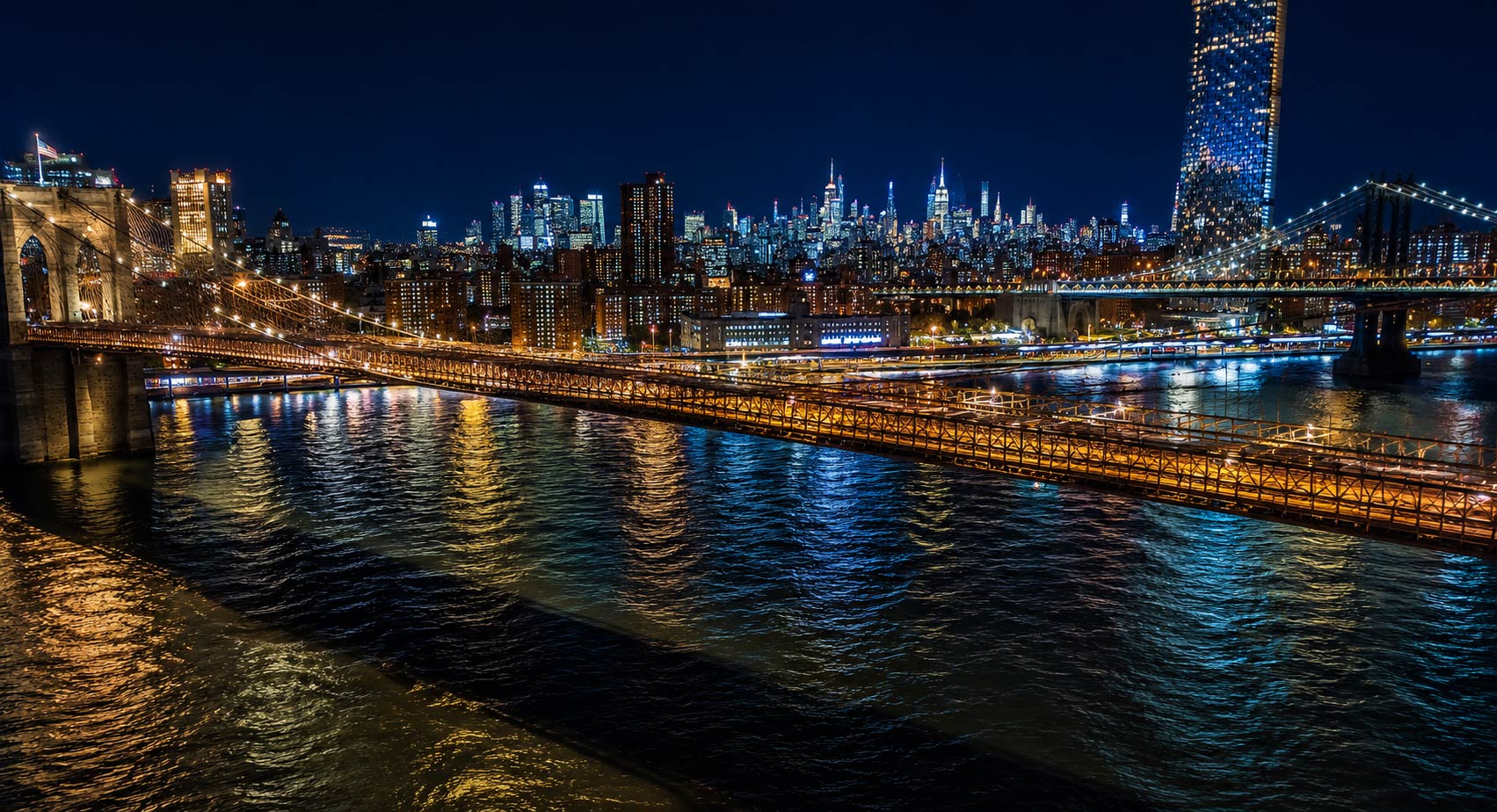 Couple watching Manhattan skyline lights during an evening New York Harbor cruise