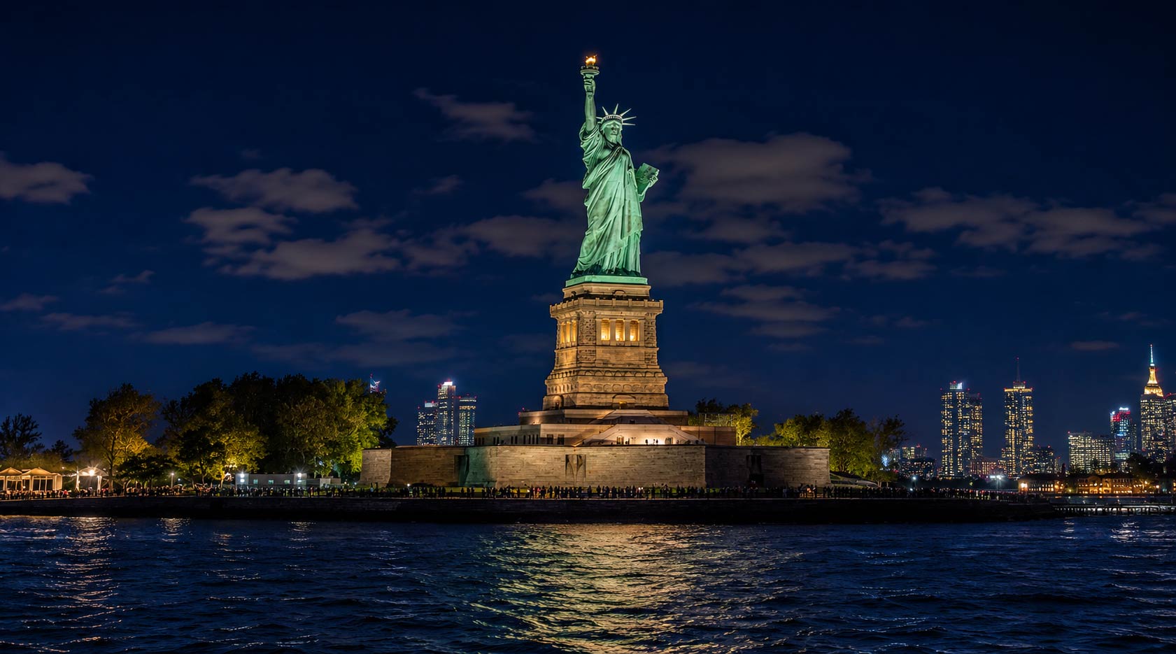 Couple posing with the Statue of Liberty during a romantic NYC sightseeing cruise